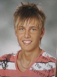 En ung man i ett fläckigt skjorta och en hatt. (AI text)