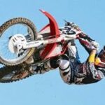 En motorsportsförare utför en trick på en smutsig motorcykel. (AI text)