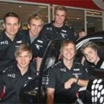 En grupp personer ställer sig upp med en bil. (AI text)