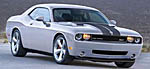 En vit Dodge Challenger SXT kör nerför en väg. (AI text)