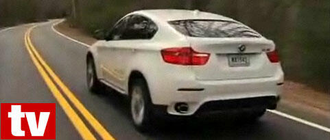 BMW X6 SUV kör längs en landsväg (AI text)