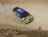 En rallybil kör längs en grusväg. (AI text)