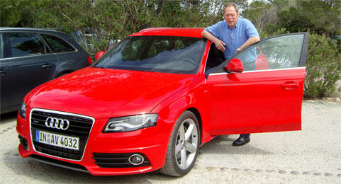 En man står bredvid en röd Audi S4. (AI text)