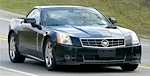 En svart Cadillac CTS kör nerför en landsväg. (AI text)