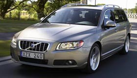 En silverfärgad Volvo V60 bagge kör längs en väg. (AI text)