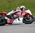 En motorcykelpilott kör på en racerbana. (AI text)