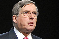 En man i kostym och slips talar. (AI text)