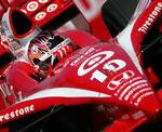 En röd Indy-car tävlar på en bana. (AI text)