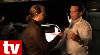 En man pratar med en man i en bil. (AI text)