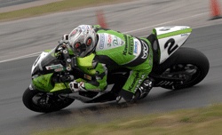 En racer på en grön motorcykel. (AI text)