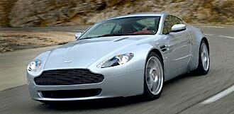 En silver Aston Martin Vantage kör nedför en bergsväg. (AI text)