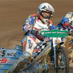 bilar och motorcyklar tävlar på en grusbilbana (AI text)