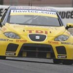 En gul racebil kör på en bana. (AI text)