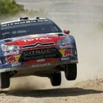En rallybil hoppar över en grusväg. (AI text)