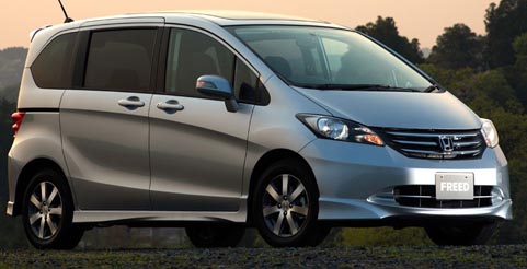 En silverfärgad Honda Odyssey parkerad på en grusväg. (AI text)