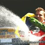 En racerförare sprutar vatten över podiet. (AI text)