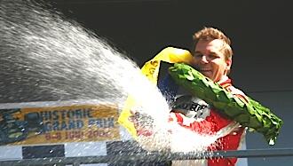 En racerförare sprutar vatten över podiet. (AI text)