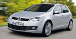 En Volkswagen Golf kör nerför en väg. (AI text)