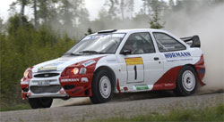 En rallybil körer längs en grusväg. (AI text)