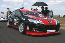 En grupp personer står bredvid en racebil. (AI text)