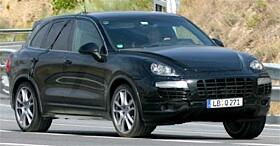 En svart Porsche Cayenne kör nerför en väg. (AI text)