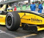 En gul och svart racerbil på en bana. (AI text)