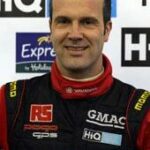 en raceförare i en röd och svart racingdräkt (AI text)