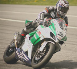 en racer på en motorcykel på en bana (AI text)