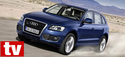En Audi Q3 SUV kör på en ökenväg. (AI text)