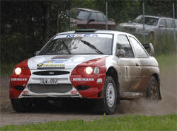 En rallybil kör på en grusväg. (AI text)