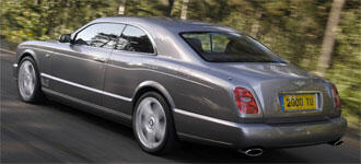 En silverfärgad Bentley parkerad vid en vägkant. (AI text)