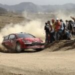En rallybil kör nerför en grusväg. (AI text)