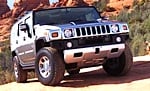 En Hummer H2 parkerad på en grusväg. (AI text)