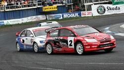 två rallybilar på en bana (AI text)