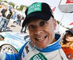 En man i en rallybil leder ett leende. (AI text)