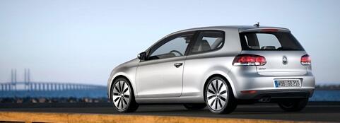 En Volkswagen Golf kör på en bro. (AI text)