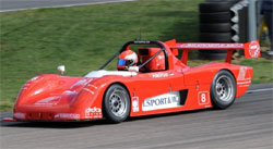 En röd racerbil kör nedför banan. (AI text)