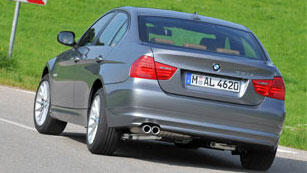 En BMW 3-serie sedan kör nerför en landsväg. (AI text)