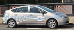 En silverfärgad Honda Prius kör ner en gata. (AI text)