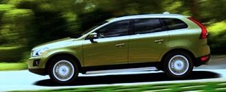 En grönt Volvo XC90 kör nerför en väg. (AI text)