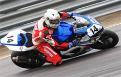 En racer kör en motorcykel längs en bana. (AI text)