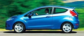 En blå Ford Fiesta kör nedför en väg. (AI text)