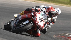 En motorcykelpilott och en racebil på en racerbana. (AI text)