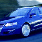 En Volkswagen Passat kör nedför en väg. (AI text)