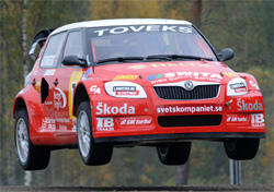 En röd Skoda Rally bil i luften. (AI text)