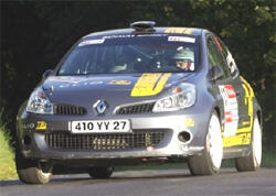 En Renault Clio RS3 tävlingsbils racer på en väg. (AI text)