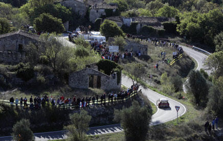 En rallybil kör nerför en backe. (AI text)