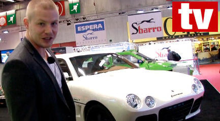 En man i kostym står bredvid en vit bil. (AI text)