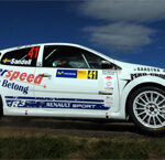 En rallybil kör på en grusväg. (AI text)