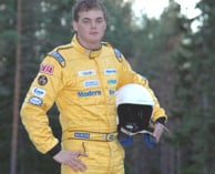 En man i ett gult loppsskjorta står i en skog. (AI text)